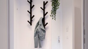 A hallway with a coat rack, a hanging plant, and a mirror reflecting the room. - RtR Herne (Herne)
