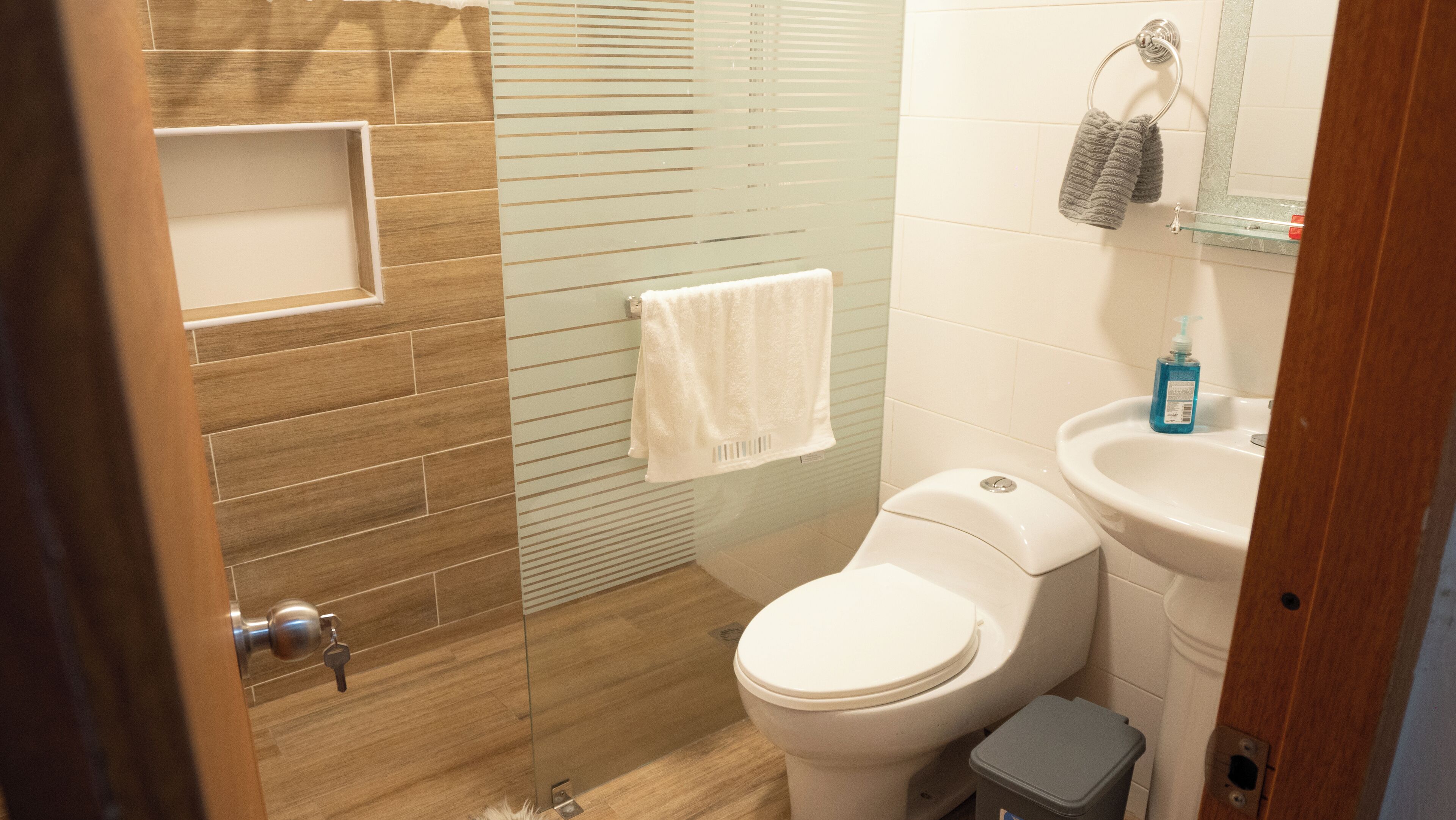 A bathroom with a toilet, sink, and shower area.