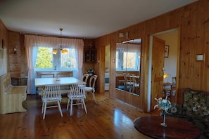 A wooden interior with a dining table, chairs, a sofa, and a mirror. - Half of a holiday home, huge garden, pond (Szymbark)