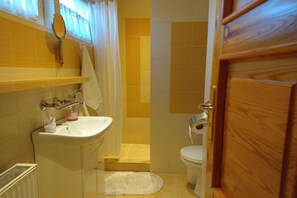 A bathroom with a sink, toilet, and shower area. - Half of a holiday home, huge garden, pond (Szymbark)