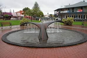 Une fontaine circulaire avec une ouverture centrale et deux extensions incurvées.