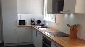 A modern kitchen with white cabinets, a wooden countertop, and a built-in oven. - WEST COAST house between ocean, Bassin d'Arcachon, Dune du Pyla, Bordeaux (Le Porge)