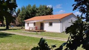 A small white building with a red roof, a wooden deck, and a bench. - WEST COAST house between ocean, Bassin d'Arcachon, Dune du Pyla, Bordeaux (Le Porge)