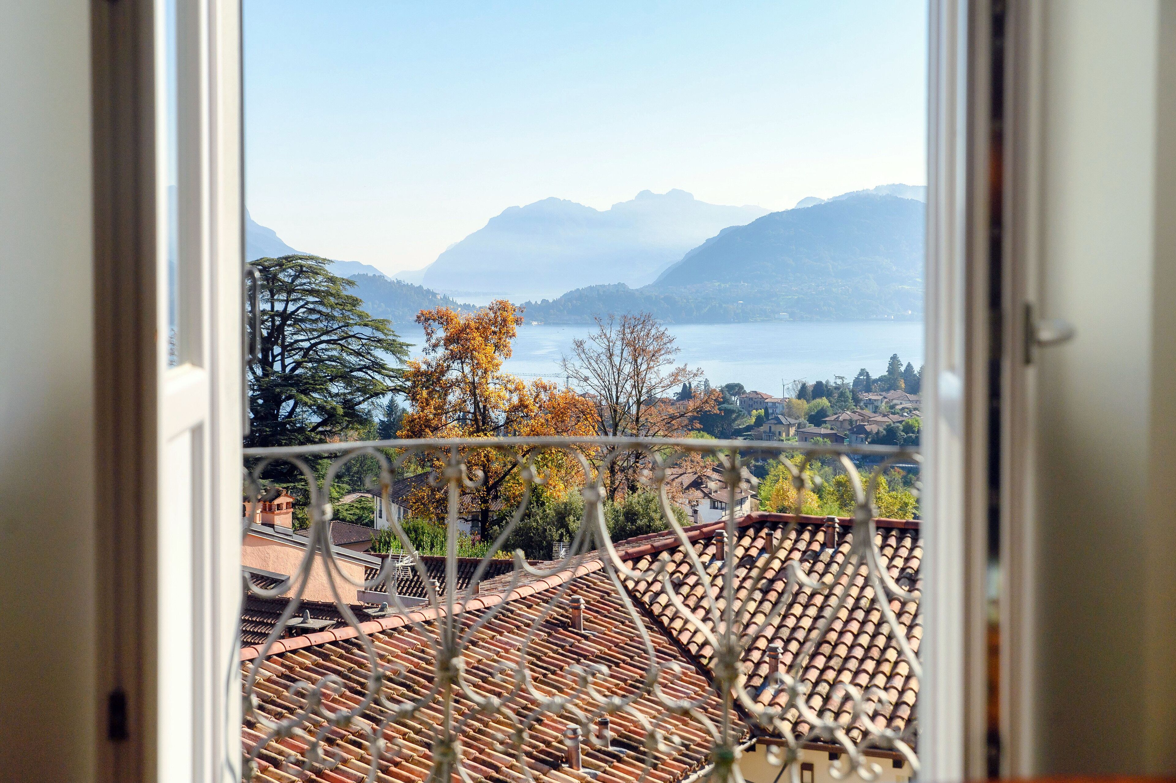 A view from a window overlooking a lake with mountains in the background.