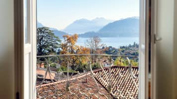 A view from a window overlooking a lake with mountains in the background.