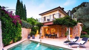 A two-story house with a swimming pool, outdoor seating, and lush greenery. - Elegant Villa with Stunning Views and Easy Beach Access (Pollenca)
