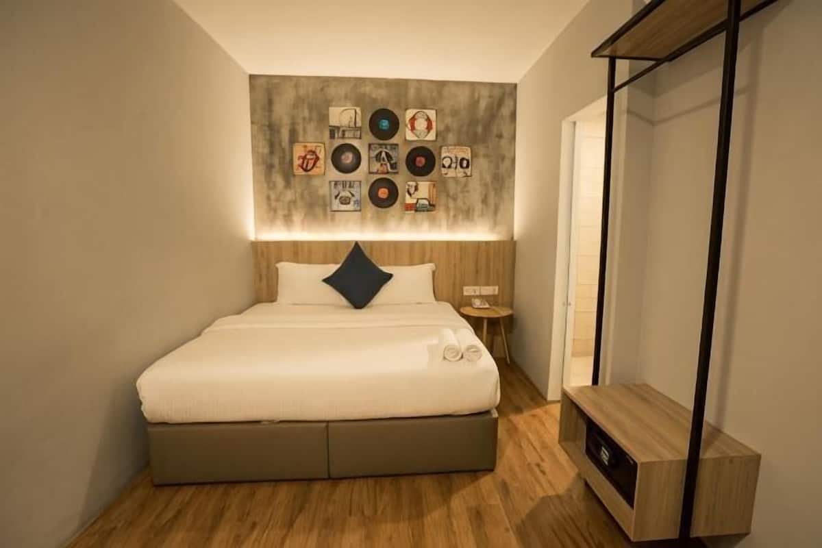 Ein ordentlich eingerichtetes Schlafzimmer mit Bett, Nachttisch und Wandbildern.