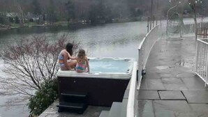 Un jacuzzi con un sendero de piedra que lleva a un lago.
