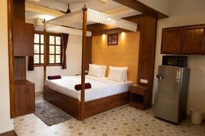 Relax in a serene bedroom with a four-poster bed, bedside table, and wardrobe.
