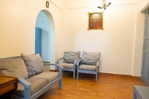 Cozy living space with a sofa, armchair, and artwork on the wall.