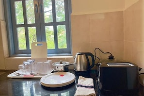 Enjoy a homey kitchen with a window overlooking lush greenery, complete with a kettle, toaster, and all the essentials.