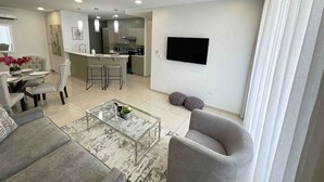 Una sala de estar moderna con un sofá, una mesa de centro y un comedor con sillas y una mesa.