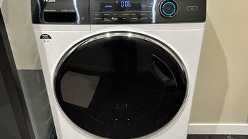 Une machine à laver Haier à entraînement direct, dotée d’un écran numérique, d’un bouton d’alimentation et d’un panneau de commande.