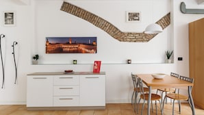 A modern kitchen with a white cabinet, a wooden dining table, and a stone archway above the counter. - Bertiera Family Duplex by Wonderful Italy (Bologna)