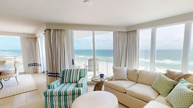 A spacious balcony with a view of the ocean, a comfortable seating area with a sofa and armchairs, and a dining table. - Seaspray West 801- Gulf Front (Pensacola)