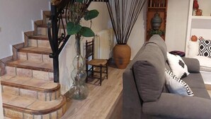 Een trap met een houten leuning en een bloempot ernaast.