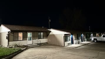 Un motel de planta baja, con un espacio de estar cubierto al aire libre y un estacionamiento.