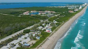 An aerial view of a coastal area with a beach, a parking lot, and a cluster of buildings. - Dockside studio in Jensen Beach (Jensen Beach)