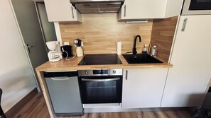 A compact kitchenette with a coffee maker, a toaster, a sink, a dishwasher, and an oven. - Apartment in Valloire at the foot of the slopes (Valloire)