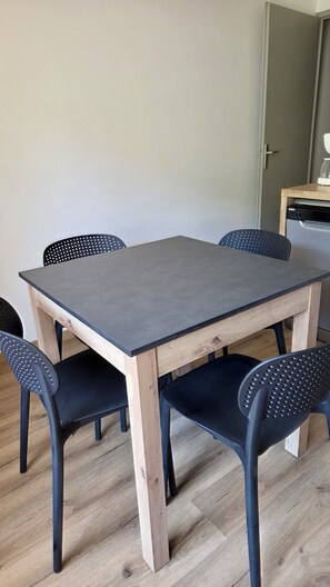 A dining table with four chairs, a coffee machine, and a dishwasher in the background. - Apartment in Valloire at the foot of the slopes (Valloire)