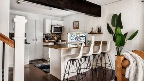 A modern kitchen with white cabinets, a stainless steel microwave, and a stained glass window. - Outlander Couples Cottage/Walk to Downtown/Hot Tub (Gatlinburg)
