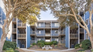 A multi-story residential building with balconies, a central courtyard, and a picnic table. - ♥New Listing Discount♥Ocean View♥Private Deck♥Newly Remodeled (North Topsail Beach)