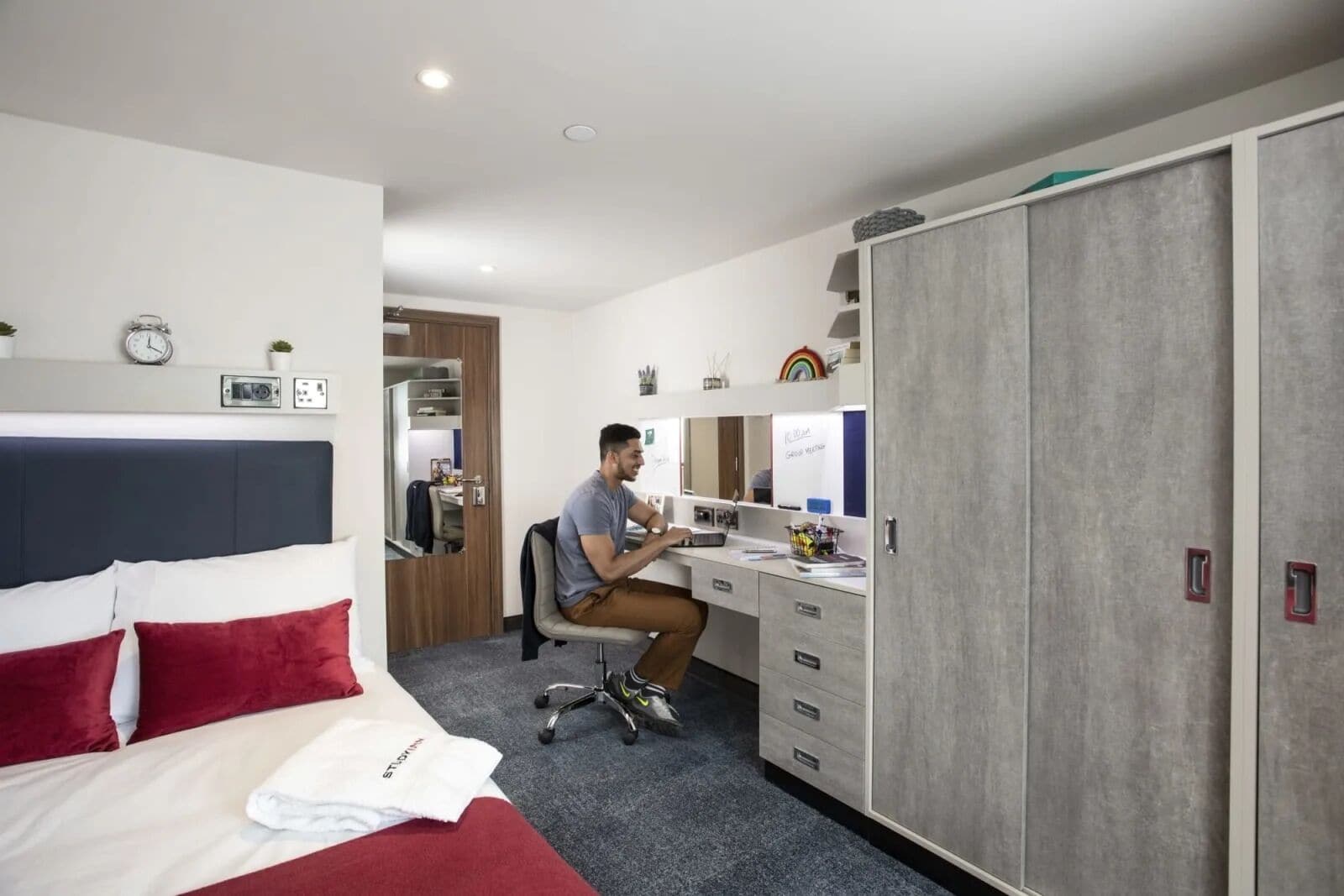 Una habitación de hotel con cama, escritorio y armario.