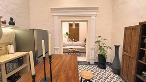 A cozy kitchen with a wooden table, a refrigerator, and a potted plant. - Casa Toto - Centro Luxe Retreat  (Mérida)