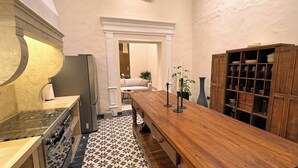 A kitchen with a wooden table, a built-in oven, and a patterned floor. - Casa Toto - Centro Luxe Retreat  (Mérida)