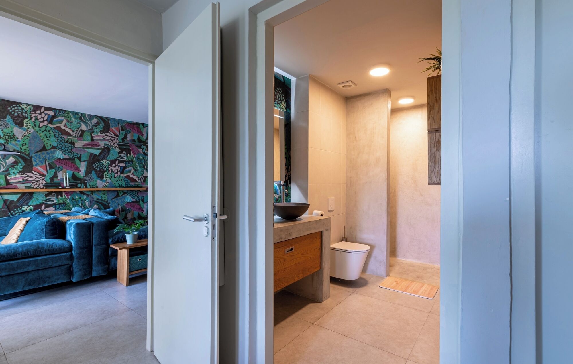 A modern bathroom with a large mirror, a bowl sink, and a shower.