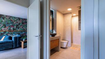 A modern bathroom with a large mirror, a bowl sink, and a shower.