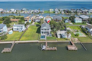 Vista aérea de una zona residencial con casas, un muelle y una masa de agua.