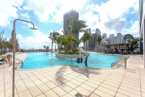 Een buitenzwembad, parasols voor strand/zwembad
