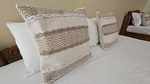 A bed with two large, textured pillows and a wooden headboard. - Ashiyana Cliff & Beach Resort by Onespace (Varkala)