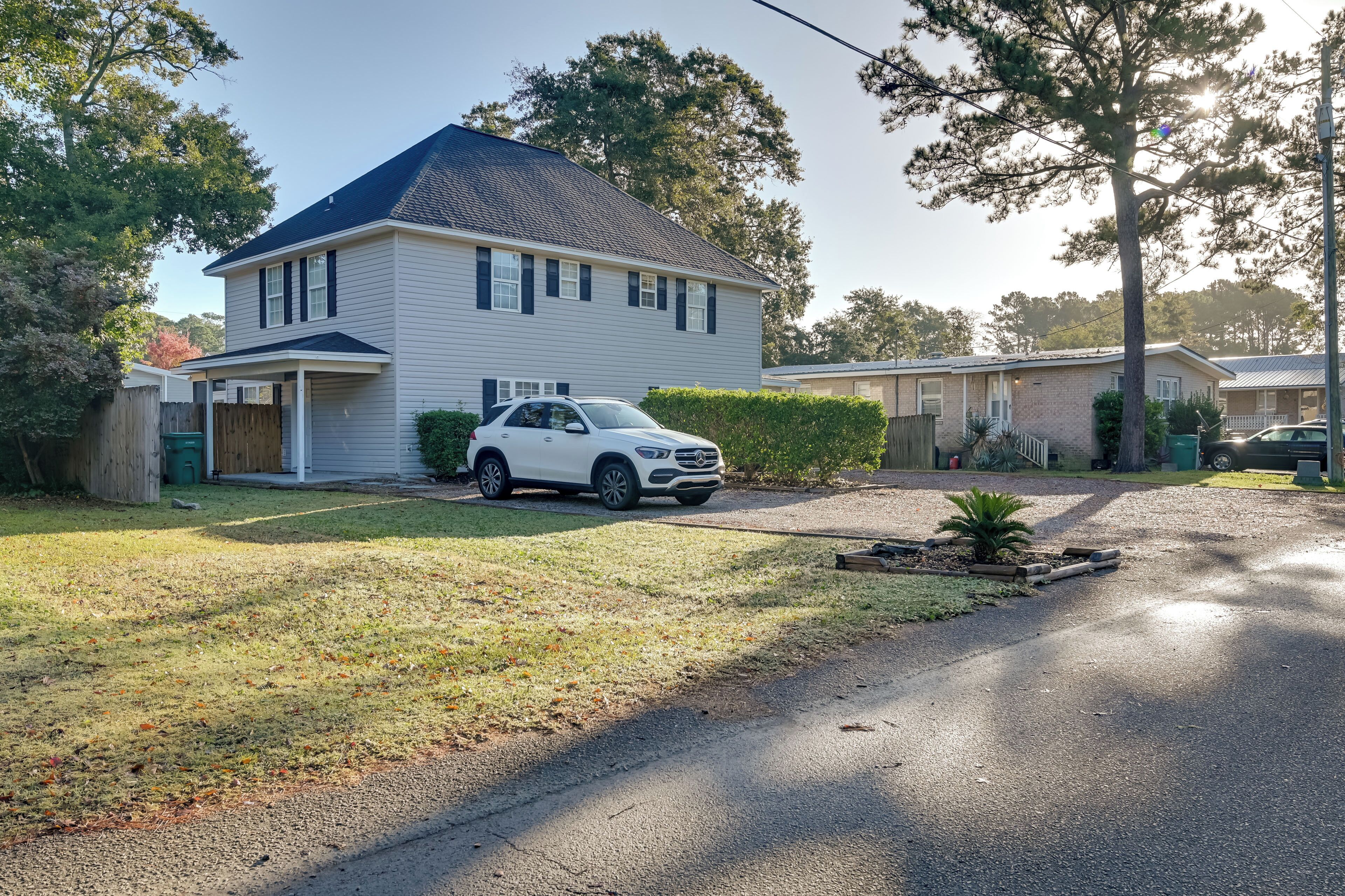 Ein zweistöckiges Haus mit Garage, Auffahrt und Rasen.
