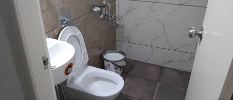 A bathroom with a toilet, bidet, and sink.