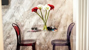 Una mesa con un florero de flores rojas y blancas, una cámara y algunos libros.