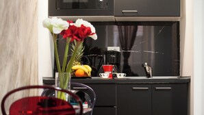 Una cocina moderna con encimera negra, cafetera y frutero.