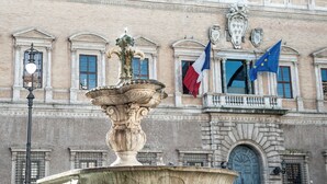 Un edificio histórico con una fuente destacada al frente.