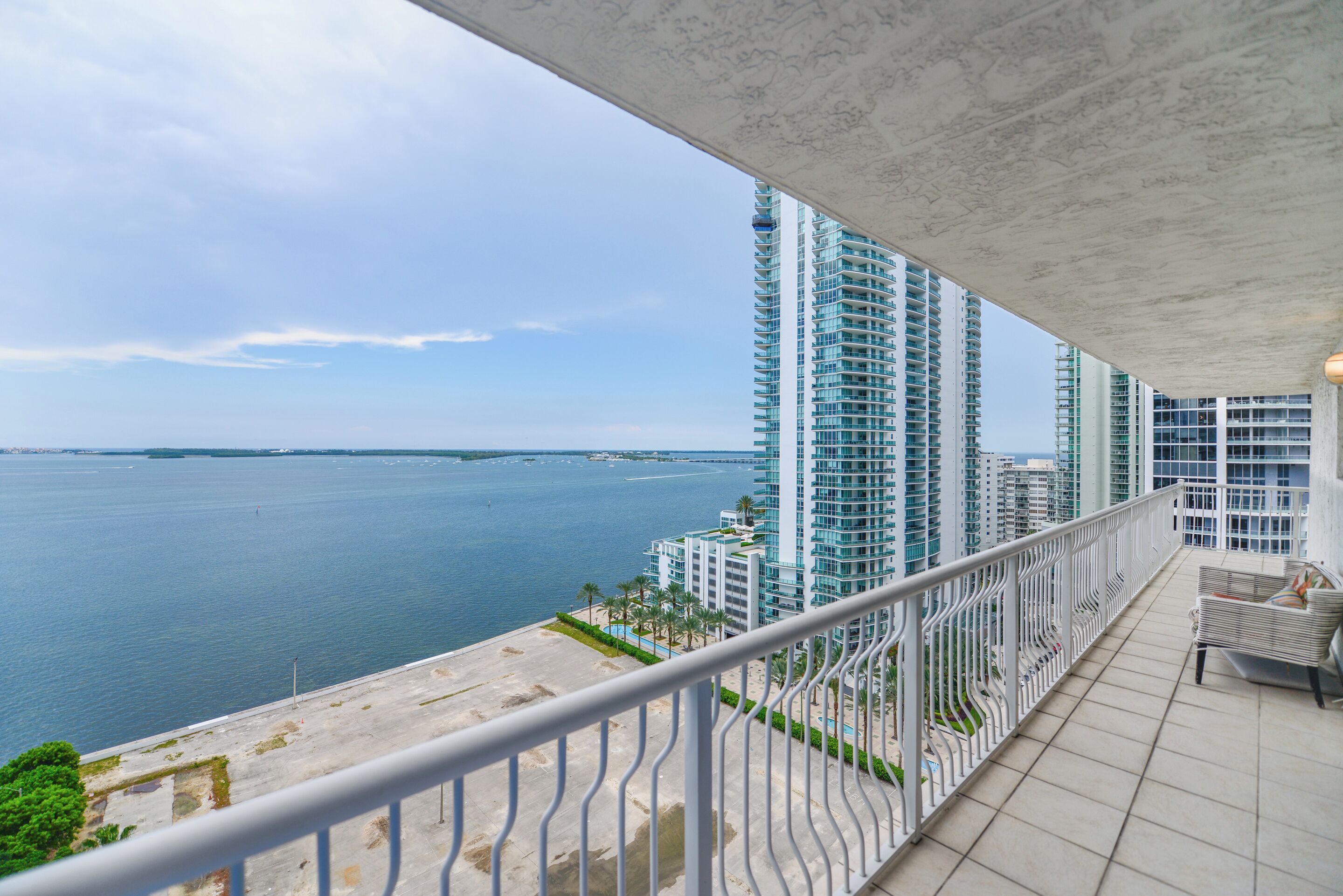 Ein Balkon mit Blick auf das Meer und hohe Gebäude.