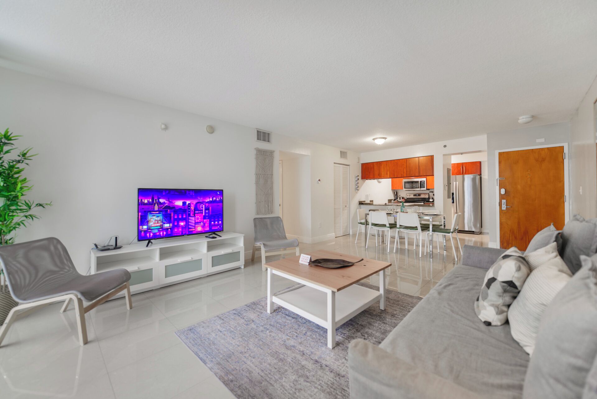 Ein modernes Wohnzimmer mit einem Flachbildfernseher, einer Couch und einem Couchtisch.