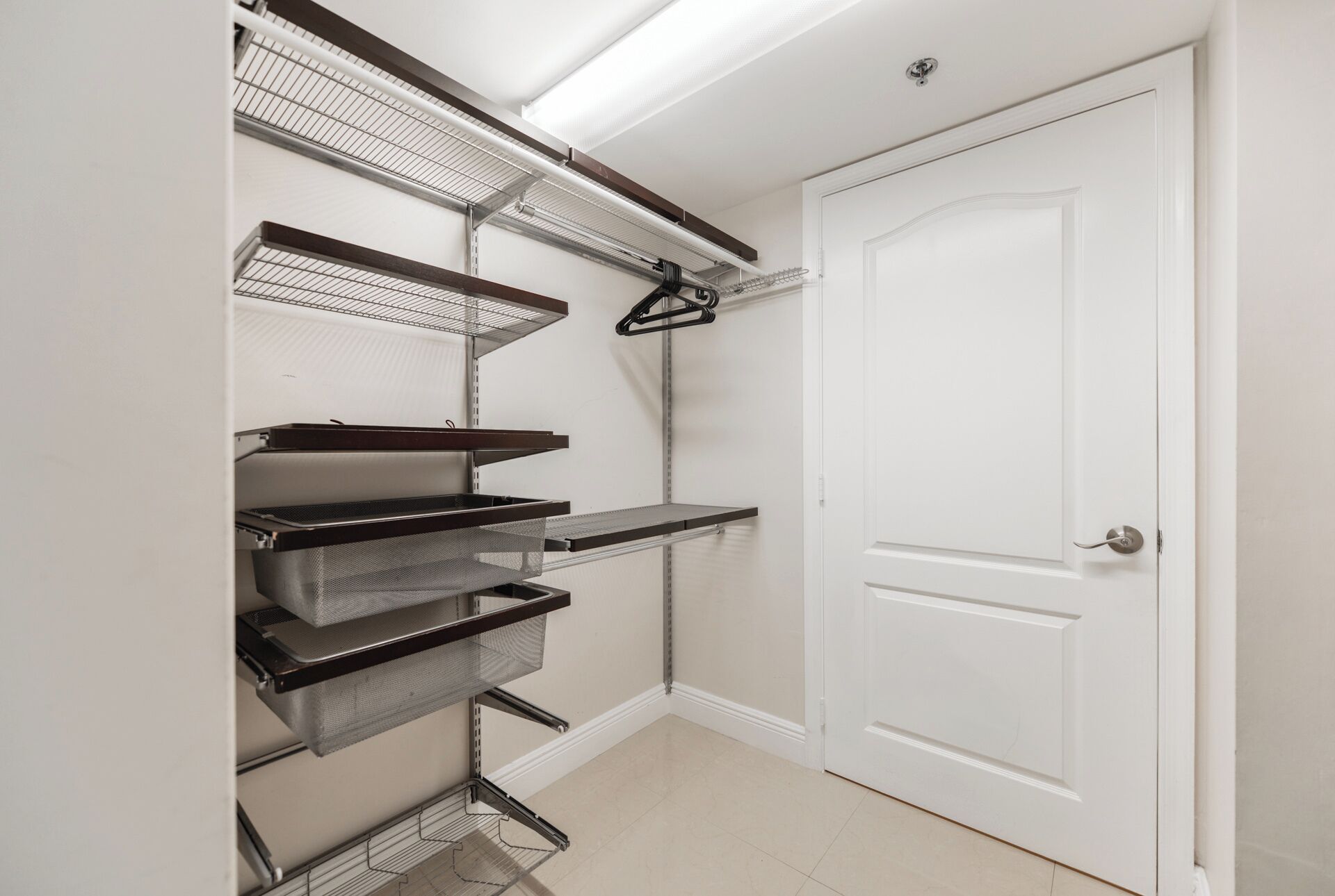 A storage closet with metal shelves and a white door.