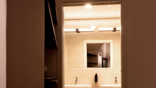 A bathroom with two sinks, a mirror, and wooden flooring.