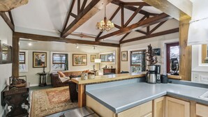 A spacious kitchen with a large island, wooden beams, and a chandelier. - Charming 1920's cottage in Afton up on bluff, river views! Swim, hike, explore! (Hastings)