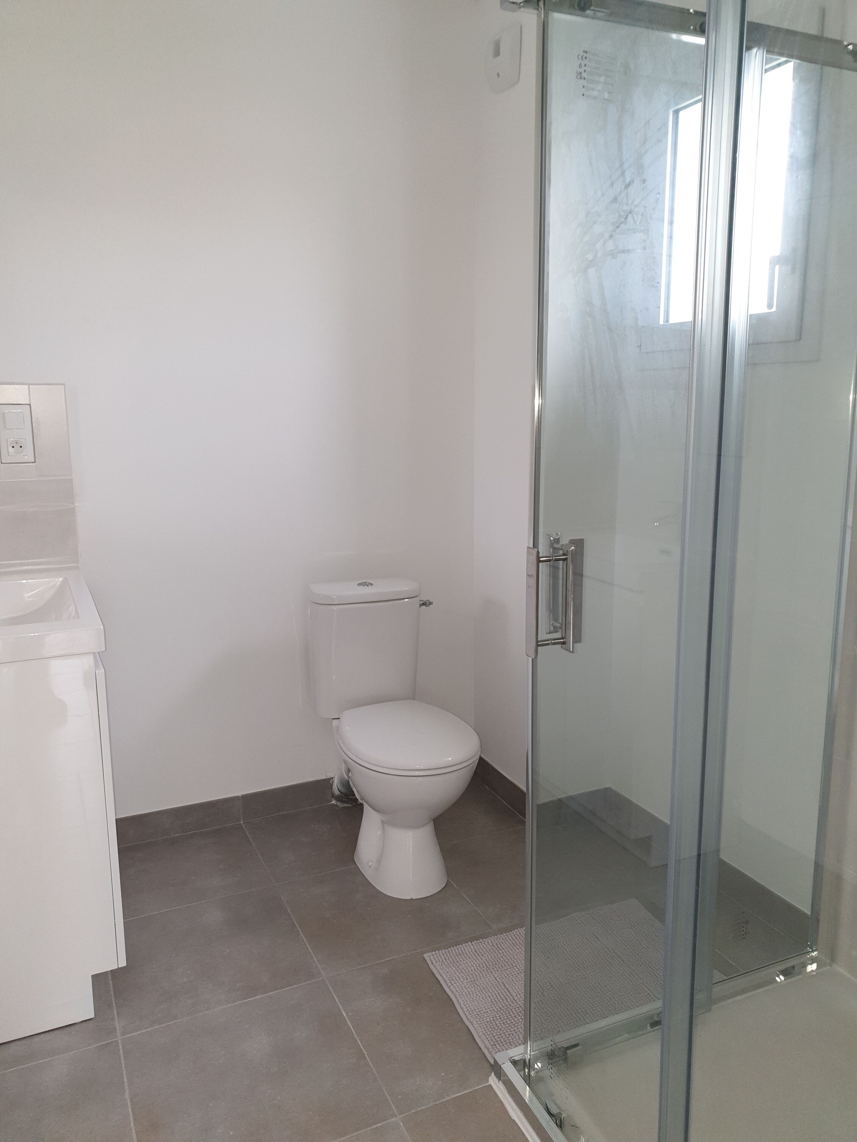 Een douche, handdoeken, zeep, toiletpapier
