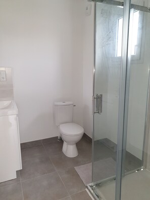 Een douche, handdoeken, zeep, toiletpapier