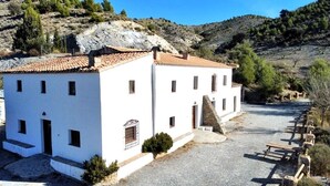 Un bâtiment blanc avec un toit en tuiles, un escalier en pierre et une allée gravillonnée.