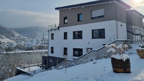 A modern building with a staircase and a view of a river and mountains in the background. - Vacation apartment MV Römervilla Loft 3 with a fantastic view of the Moselle in Treis-Karden COC (Treis-Karden)