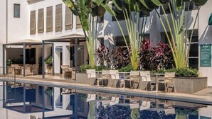 A poolside area with outdoor seating and lush tropical plants. - Hidden Gem Luxe Suite w Pool View - 1km to Beach (Candolim)