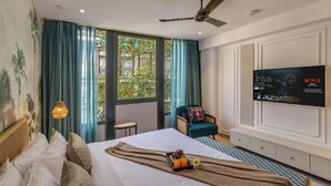 A hotel room with a bed, a chair, a TV, and a window with curtains. - Hidden Gem Luxe Suite w Pool View - 1km to Beach (Candolim)